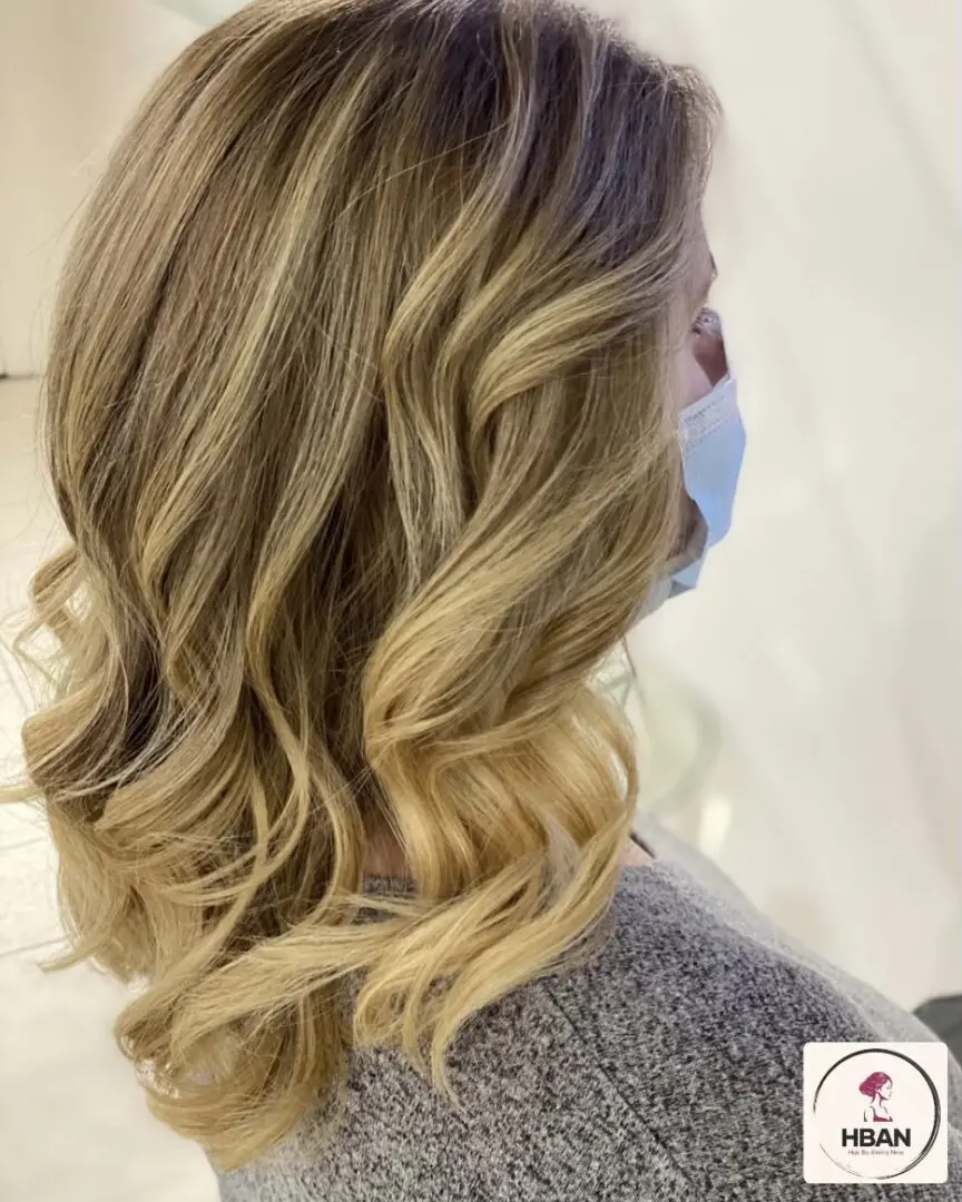 long wavy smooth brown and blonde curly hair of a woman